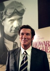 Richard Gere con alle spalle una foto di Howard Hughes in una scena di L'imbroglio - The Hoax