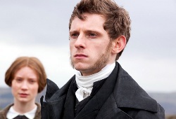 Jamie Bell con Tamzin Merchant sullo sfondo in una scena di Jane Eyre