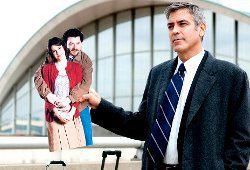 George Clooney con in mano la fotografia di Danny McBride e Melanie Lynskey in una scena di Tra le nuvole